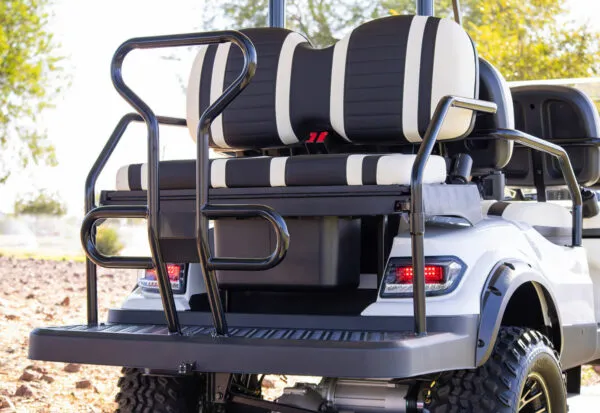 Rear view of ICON i60L lifted 6-seat electric golf cart showing premium wheels and handrails